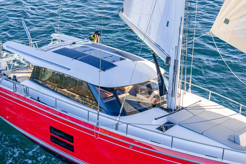 In Stock - W / Warranty Yacht Photos Pics 2024 Moody 41ds sailboat with red hull, sleek design, and spacious deck on open water.