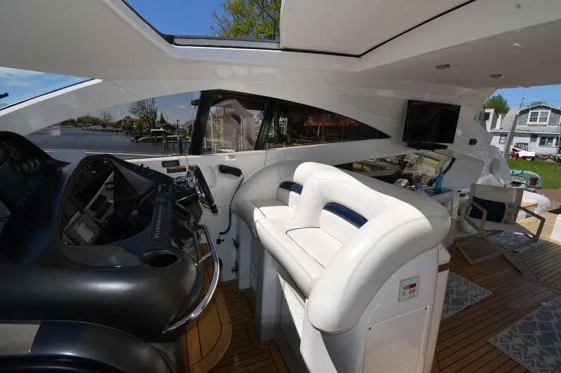Loudmouth Soup Yacht Photos Pics Interior view of 2002 Sunseeker 68 Predator yacht with sleek helm and white seating.