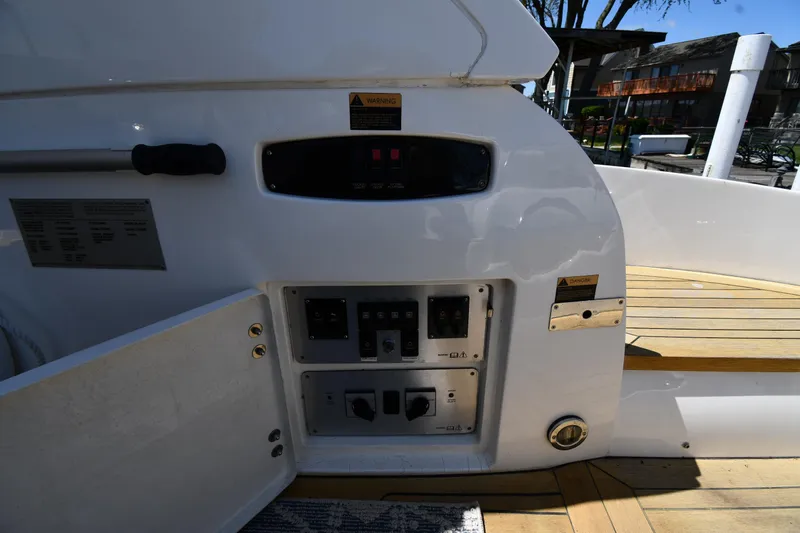Loudmouth Soup Yacht Photos Pics Control panel on a 2002 Sunseeker 68 Predator yacht, featuring open access and wooden deck.