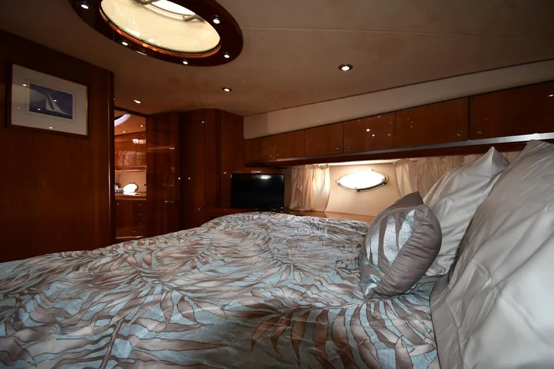 Loudmouth Soup Yacht Photos Pics Luxurious bedroom interior of 2002 Sunseeker 68 Predator yacht with elegant bedding and wood finishes.
