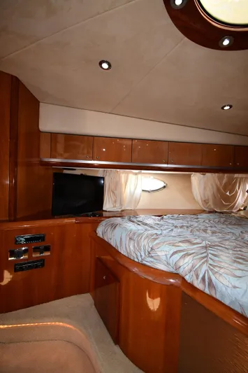 Loudmouth Soup Yacht Photos Pics Luxurious cabin interior of 2002 Sunseeker 68 Predator yacht with wood finish and cozy bedding.