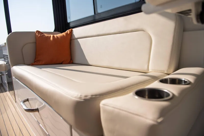 Key East Yacht Photos Pics Luxurious seating on 2023 MJM 3 boat with beige upholstery and orange cushion.