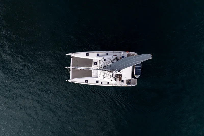 Wikiwiki Yacht Photos Pics Aerial view of 2018 Outremer 5X catamaran sailing on dark blue water.