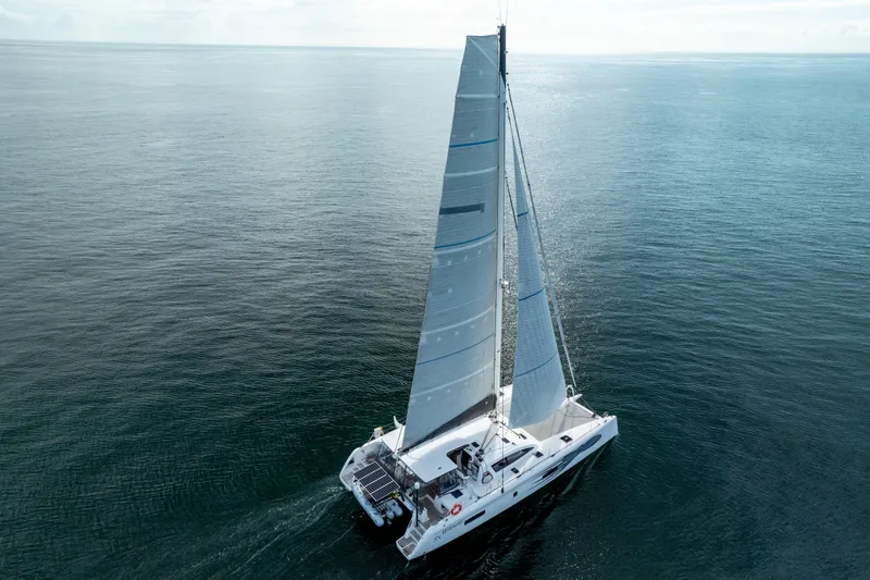 Wikiwiki Yacht Photos Pics 2018 Outremer 5X catamaran sailing on open sea, aerial view.