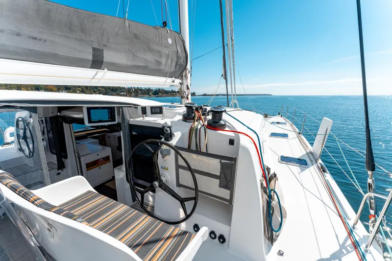 Wikiwiki Yacht Photos Pics 2018 Outremer 5X sailboat cockpit with steering wheel, open sea view, and clear blue sky.