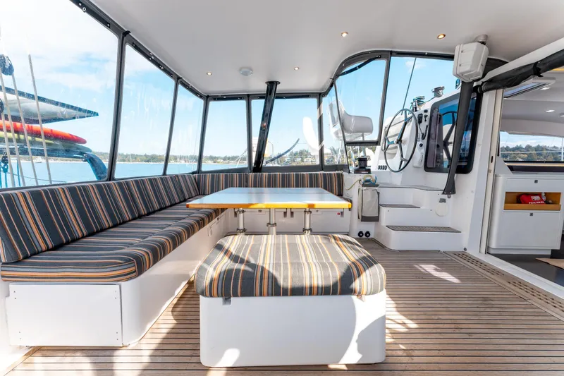 Wikiwiki Yacht Photos Pics Spacious interior of 2018 Outremer 5X catamaran with striped seating and panoramic windows.