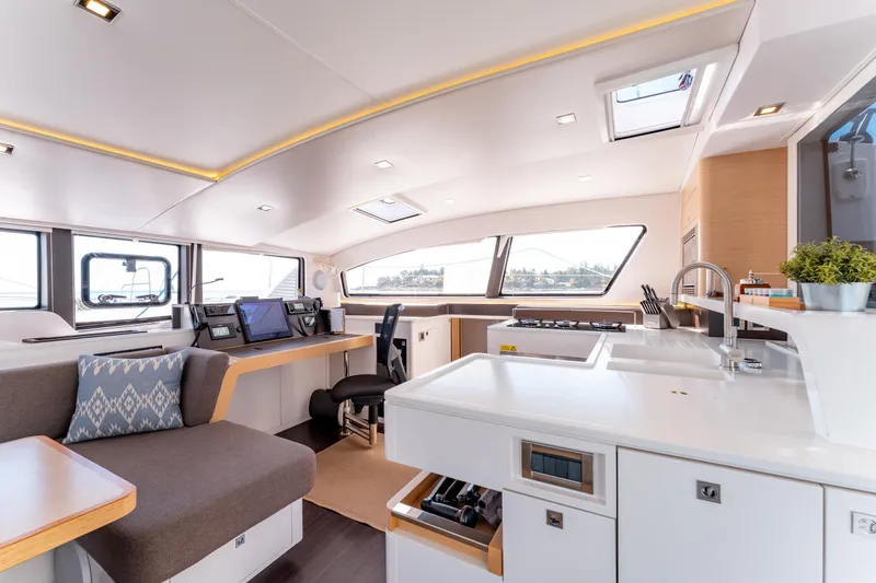 Wikiwiki Yacht Photos Pics Luxurious interior of 2018 Outremer 5X catamaran with modern kitchen and navigation area.