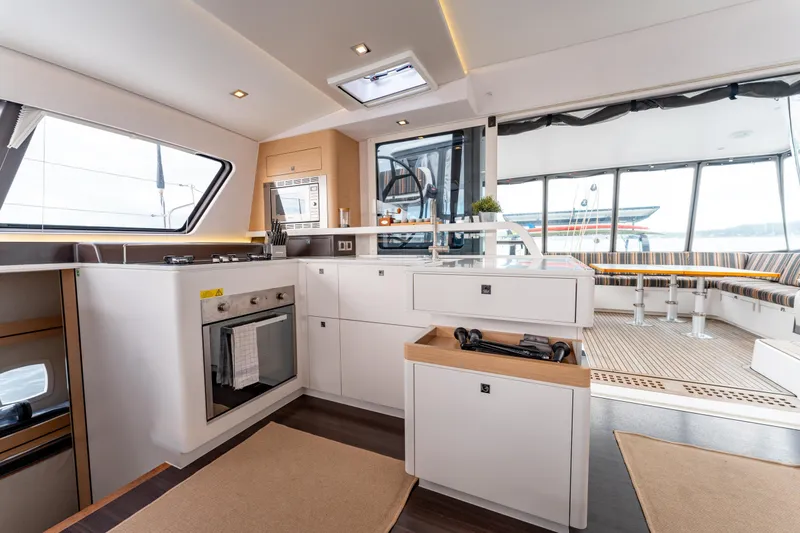 Wikiwiki Yacht Photos Pics Luxurious interior of 2018 Outremer 5X catamaran with modern kitchen and spacious seating area.