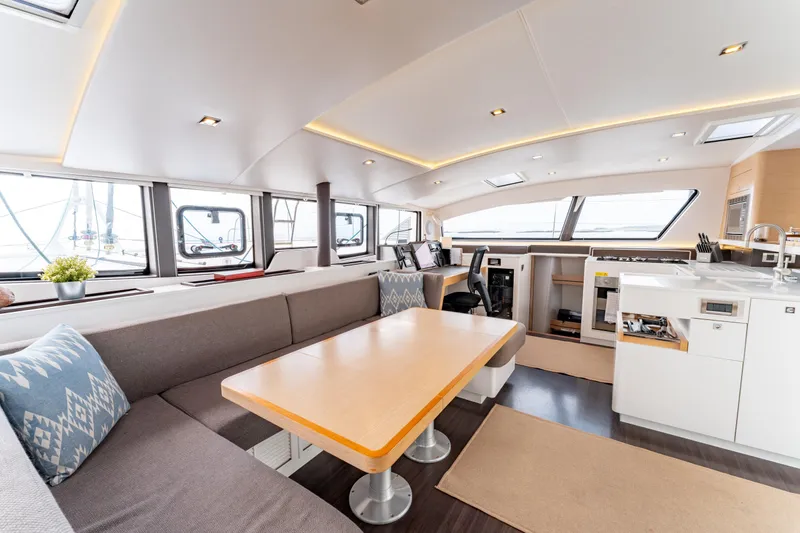 Wikiwiki Yacht Photos Pics Luxurious interior of 2018 Outremer 5X catamaran with modern seating and kitchen area.