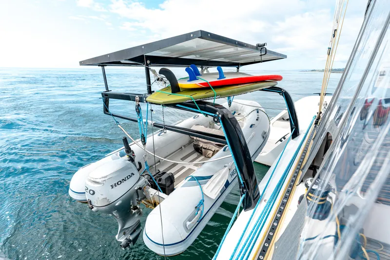 Wikiwiki Yacht Photos Pics Outremer 5X 2018 catamaran with dinghy and surfboards on a sunny ocean day.