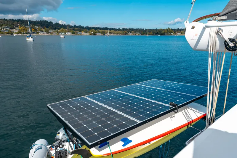 Wikiwiki Yacht Photos Pics Outremer 5X 2018 catamaran with solar panels on calm water, scenic background.