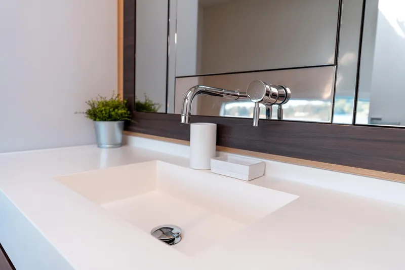 Wikiwiki Yacht Photos Pics Modern bathroom sink with sleek faucet, mirror, and potted plant on Outremer 5X yacht, 2018.