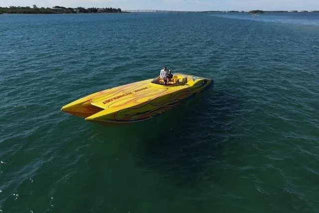  Yacht Photos Pics Yellow 2007 MTI 40RP speedboat with flame design on open water.