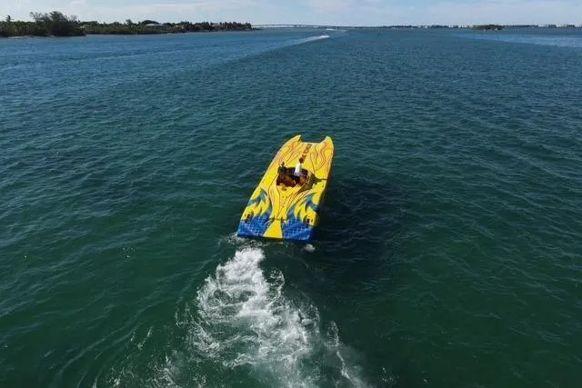  Yacht Photos Pics Aerial view of a 2007 MTI 40RP speedboat with vibrant yellow and blue design on open water.
