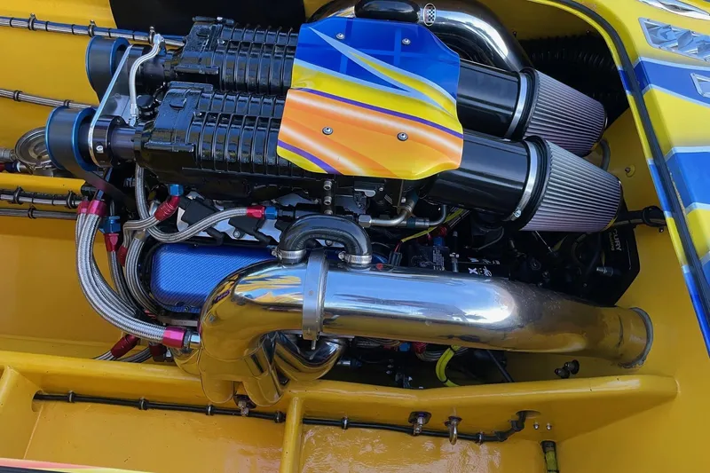  Yacht Photos Pics High-performance engine of a 2007 MTI 40RP boat, featuring vibrant yellow and blue accents.