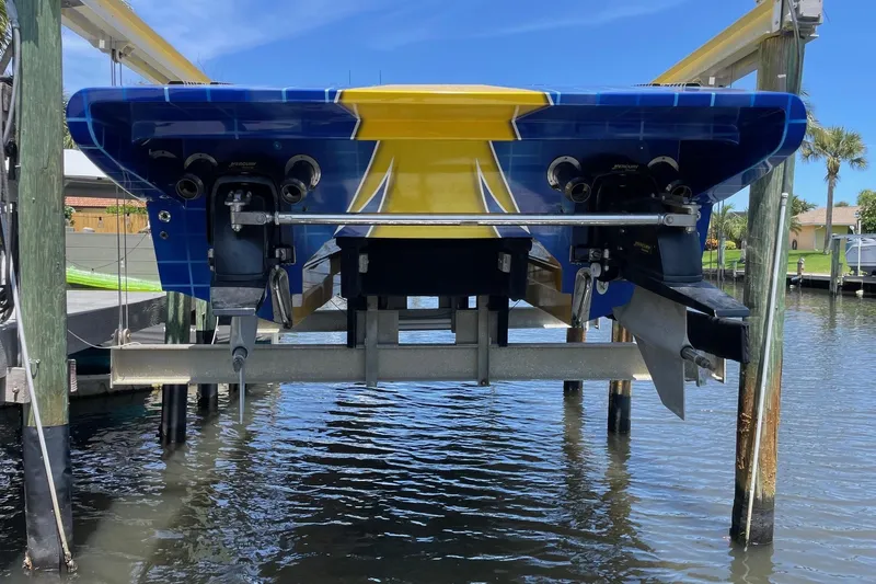  Yacht Photos Pics 2007 MTI 40RP boat on lift, vibrant blue and yellow design, docked by water.