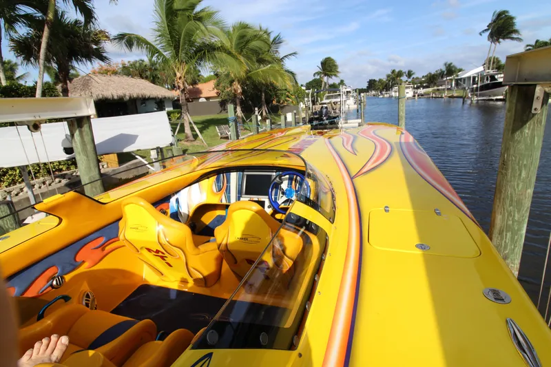  Yacht Photos Pics Bright yellow 2007 MTI 40RP speedboat with vibrant interior, docked by a tropical canal.