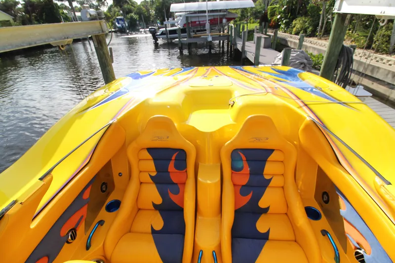  Yacht Photos Pics Yellow 2007 MTI 40RP speedboat with vibrant flame-patterned seats docked by the water.