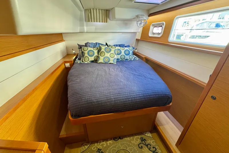 Tomcat Yacht Photos Pics Cozy cabin interior of 2012 Lagoon 450 F yacht with bed and porthole window.