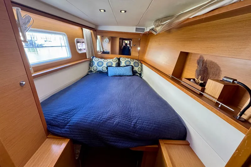 Tomcat Yacht Photos Pics Cozy cabin interior of 2012 Lagoon 450 F yacht with blue bedding and wooden accents.