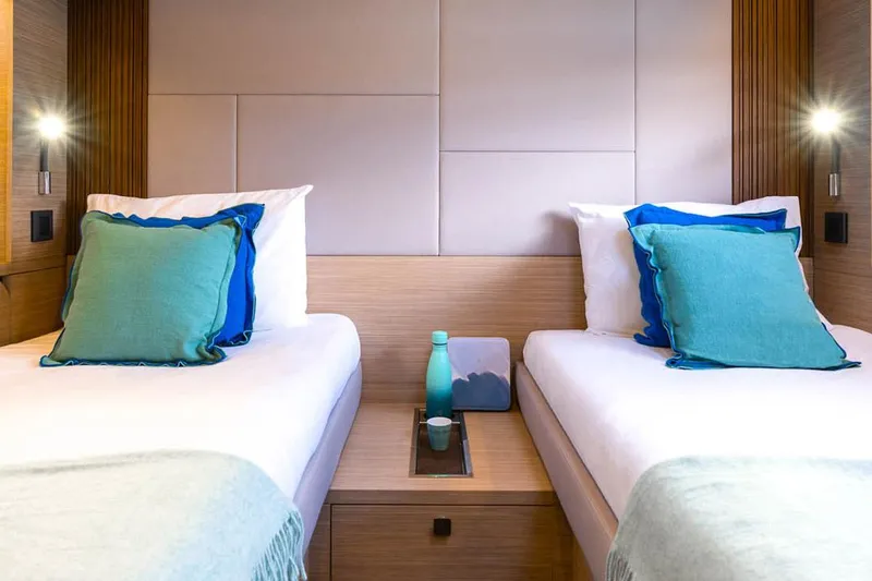  Yacht Photos Pics Manufacturer Provided Image: Luxurious twin cabin interior of 2025 Lagoon 60 yacht with modern decor and ambient lighting.