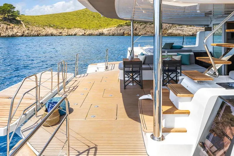  Yacht Photos Pics Manufacturer Provided Image: Luxurious 2025 Lagoon 60 yacht deck with seating, overlooking serene blue waters and lush coastline.