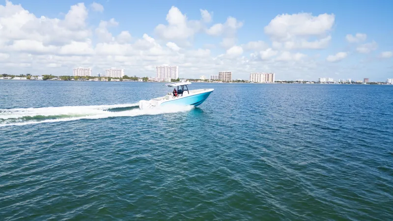  Yacht Photos Pics Century 3200 Center Console boat cruising on open water, 2019 model, under a clear blue sky.