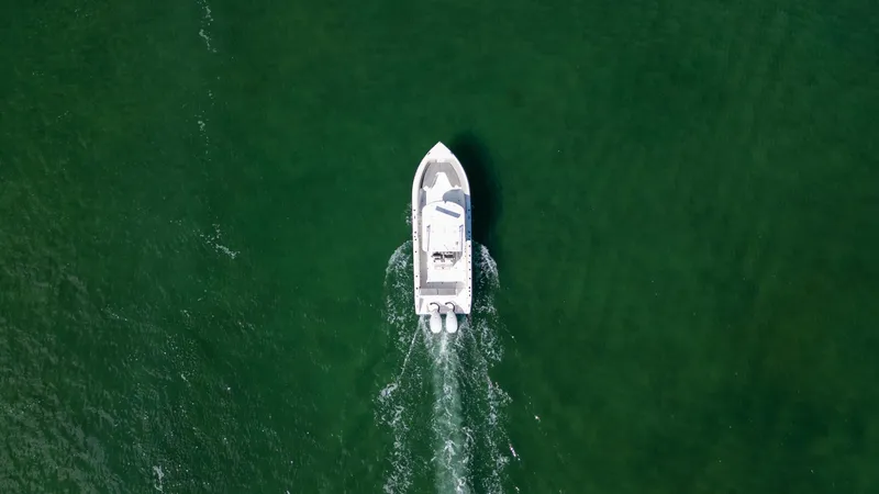  Yacht Photos Pics Aerial view of 2019 Century 3200 Center Console boat cruising on green water.