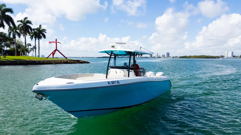  Yacht Photos Pics 2019 Century 3200 Center Console boat cruising on a sunny day near palm trees.