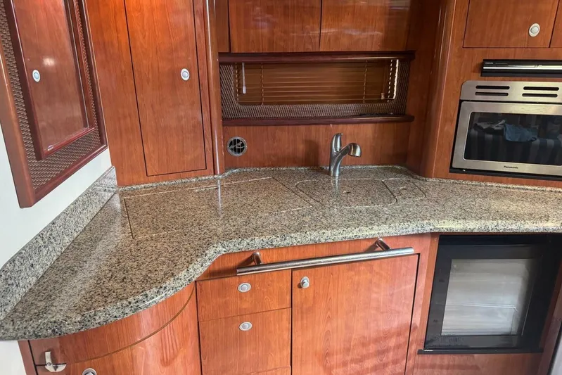 Patry-sea Yacht Photos Pics Luxurious 2005 Sea Ray 420 Sundancer yacht kitchen with granite countertops and wooden cabinetry.