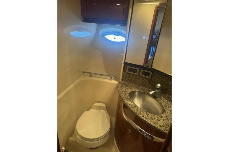 Patry-sea Yacht Photos Pics Luxurious bathroom in 2005 Sea Ray 420 Sundancer yacht with granite countertop and porthole.