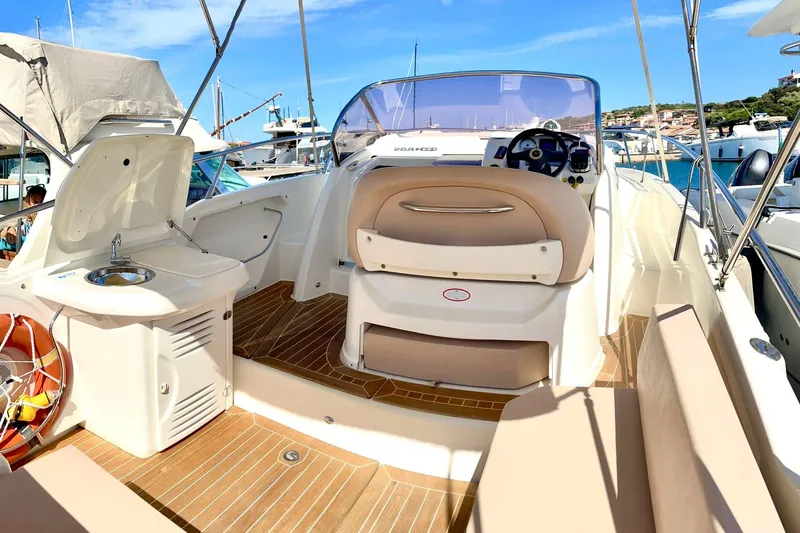  Yacht Photos Pics 2012 Cranchi Endurance 30 boat interior with helm, seating, and sink, docked in a marina.