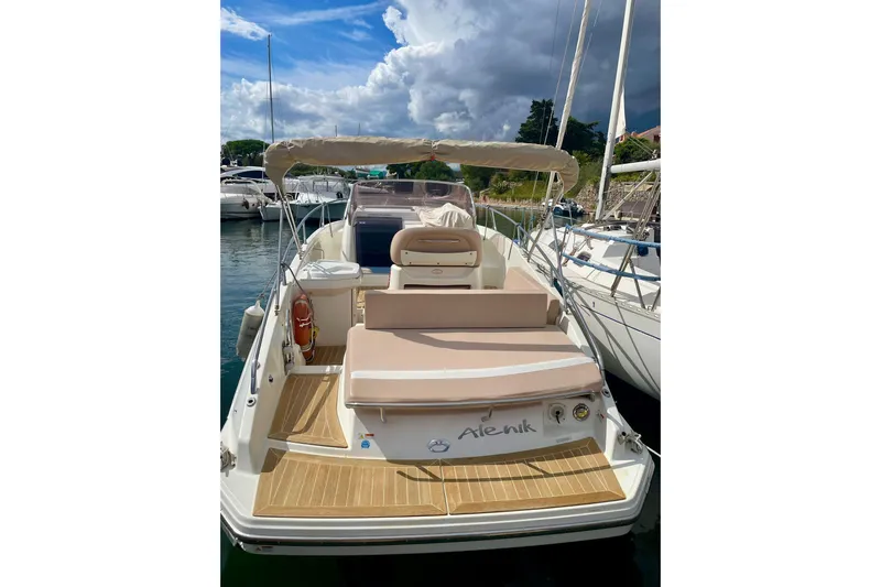  Yacht Photos Pics 2012 Cranchi Endurance 30 boat docked, featuring beige seating and canopy under a cloudy sky.