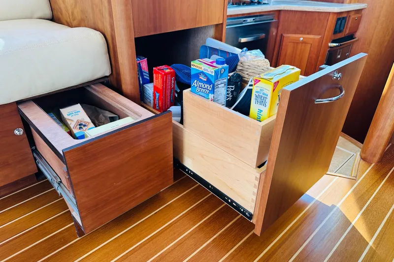 Encore Yacht Photos Pics Interior storage of 2017 Sabre 42 Salon Express yacht with wooden drawers and pantry items.