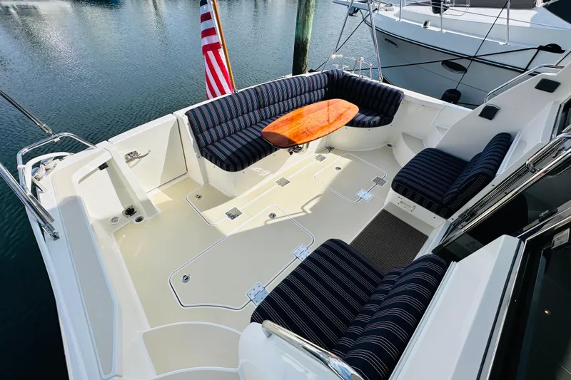 Encore Yacht Photos Pics 2017 Sabre 42 Salon Express yacht cockpit with striped seating and wooden table.