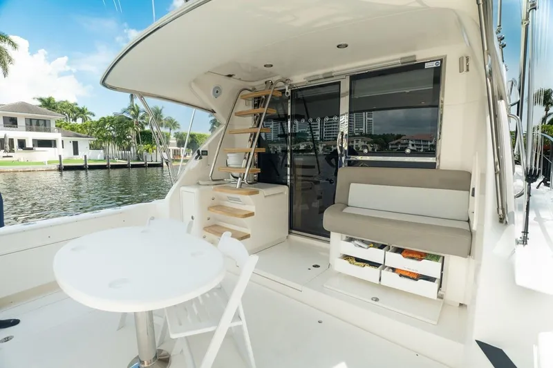 No. 7 Yacht Photos Pics 2018 Riviera 43 Open Flybridge yacht deck with seating, table, and waterfront view.