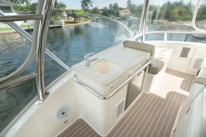 No. 7 Yacht Photos Pics 2018 Riviera 43 Open Flybridge interior with sink, seating, and scenic waterway view.