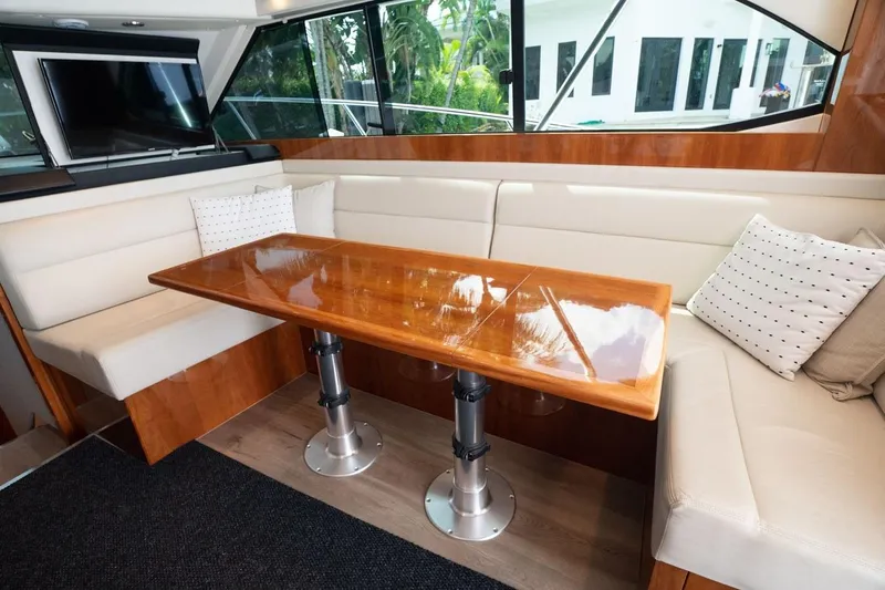 No. 7 Yacht Photos Pics Luxurious interior of 2018 Riviera 43 Open Flybridge with polished wood table and plush seating.