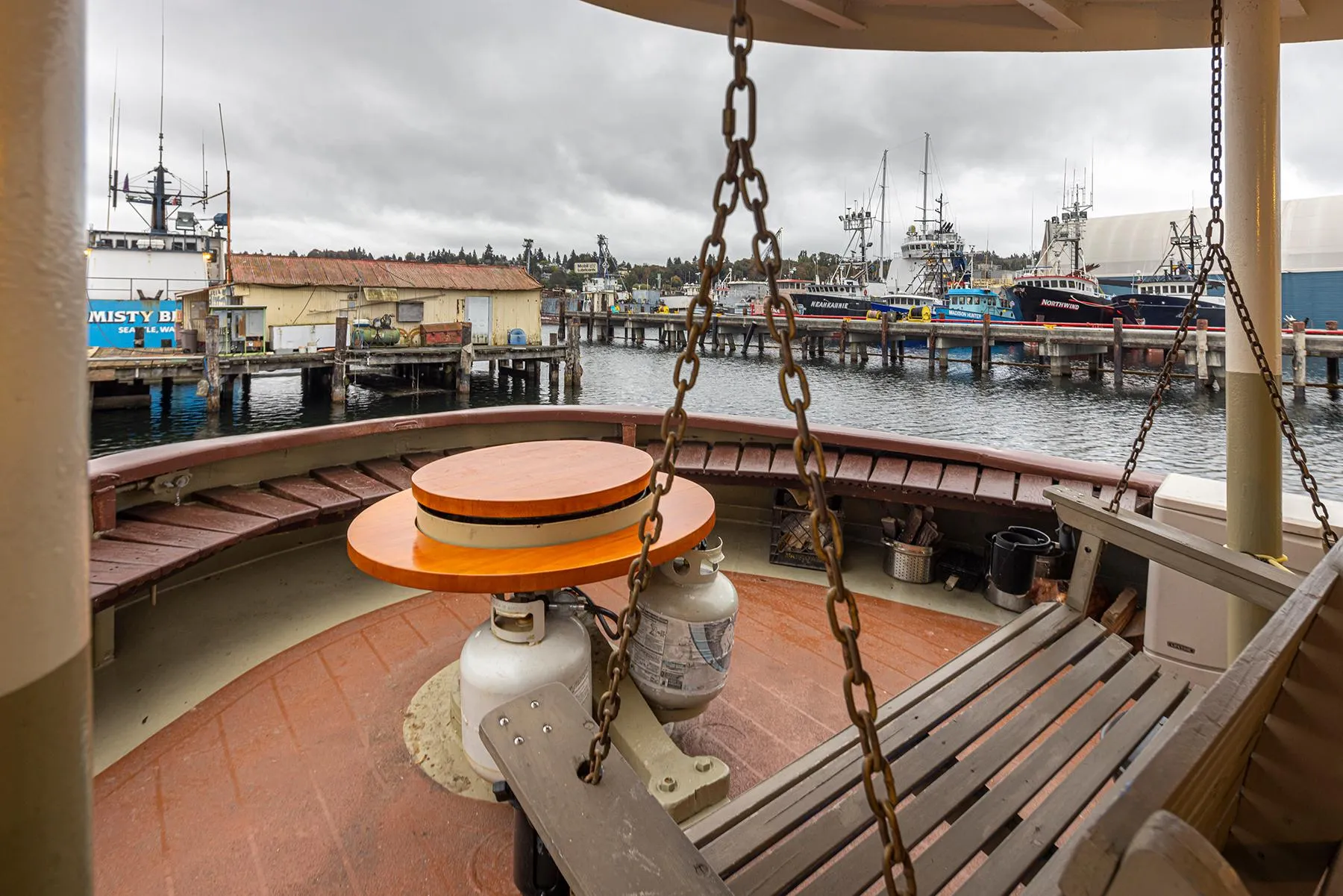 1943 Custom Navy Tugboat deck with benches, chains, and harbor view.