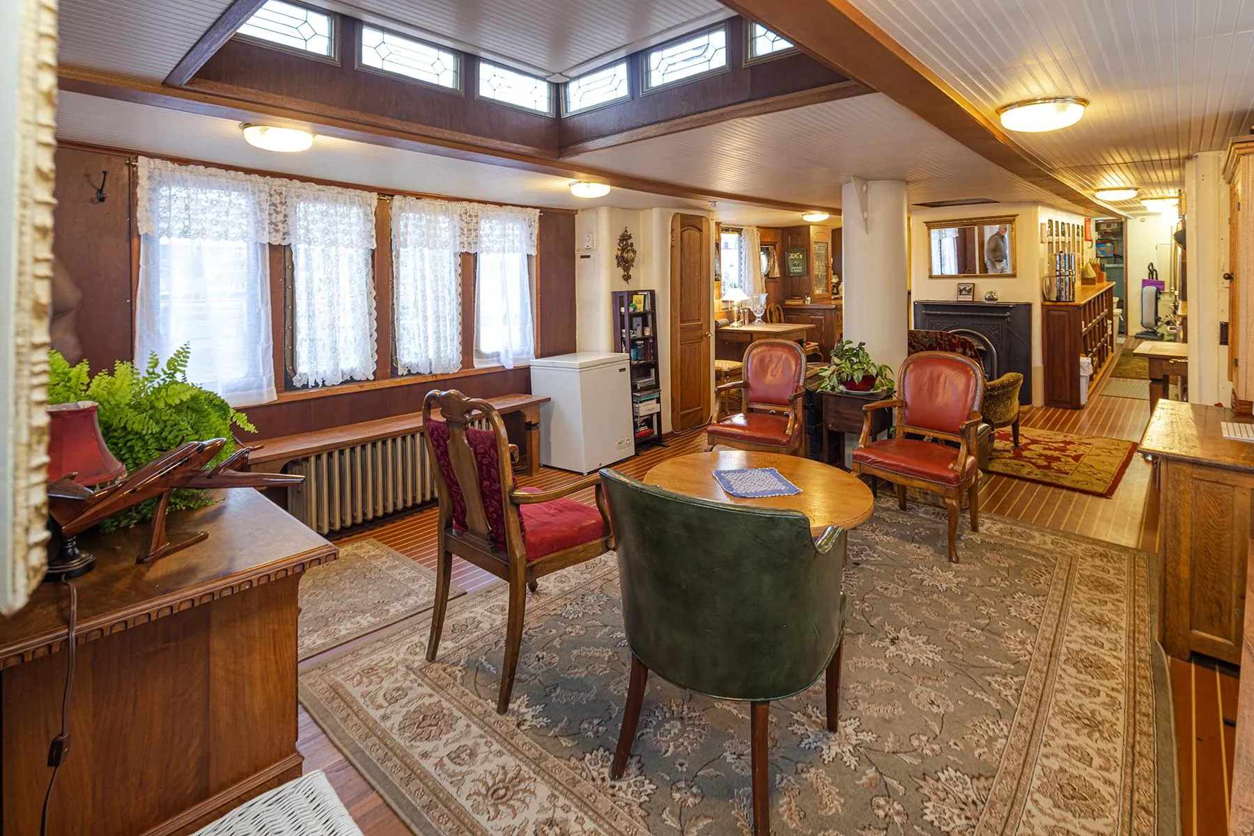 Cozy 1943 Custom Navy Tug interior with vintage furniture and warm lighting.
