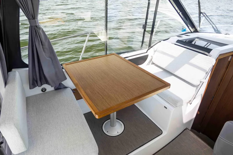  Yacht Photos Pics Interior of 2022 Jeanneau NC Weekender 895, featuring a cozy seating area with a wooden table.