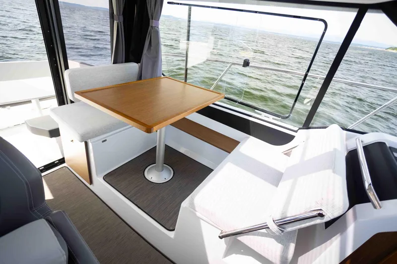  Yacht Photos Pics Interior of 2022 Jeanneau NC Weekender 895 with dining area and sea view.