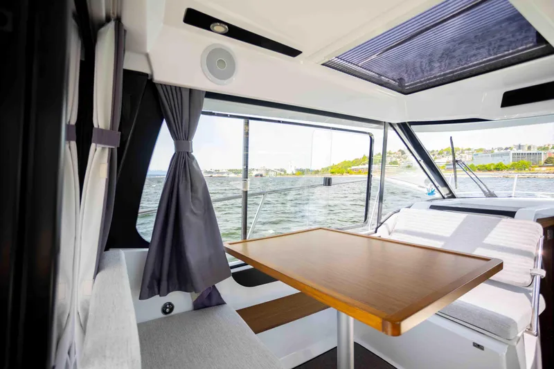  Yacht Photos Pics Interior of 2022 Jeanneau NC Weekender 895 with dining area and scenic window view.