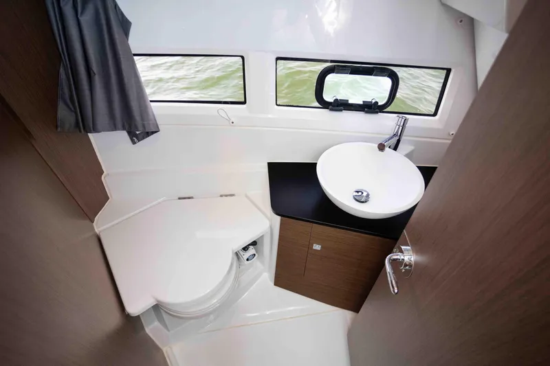  Yacht Photos Pics 2022 Jeanneau NC Weekender 895 bathroom with modern sink, toilet, and window view.