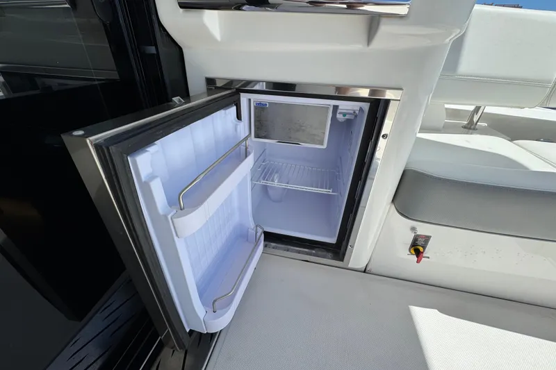 Carchi Yacht Photos Pics Open mini fridge on 2022 Regal 42 XO yacht, showcasing interior storage space.
