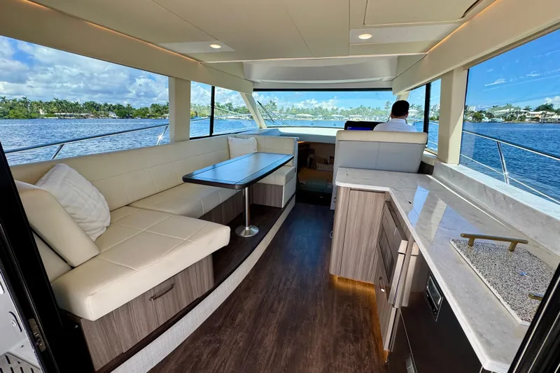 Carchi Yacht Photos Pics Luxurious interior of 2022 Regal 42 XO yacht with elegant seating and panoramic windows.