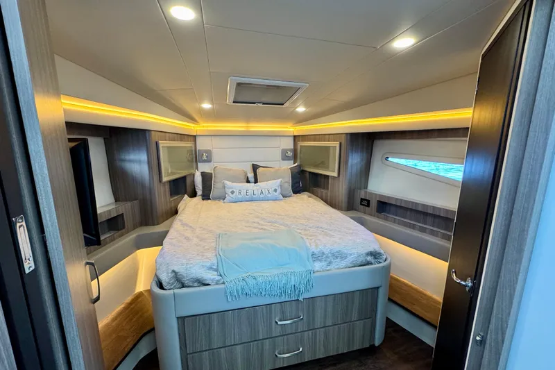 Carchi Yacht Photos Pics Luxurious cabin interior of 2022 Regal 42 XO yacht with cozy bed and ambient lighting.