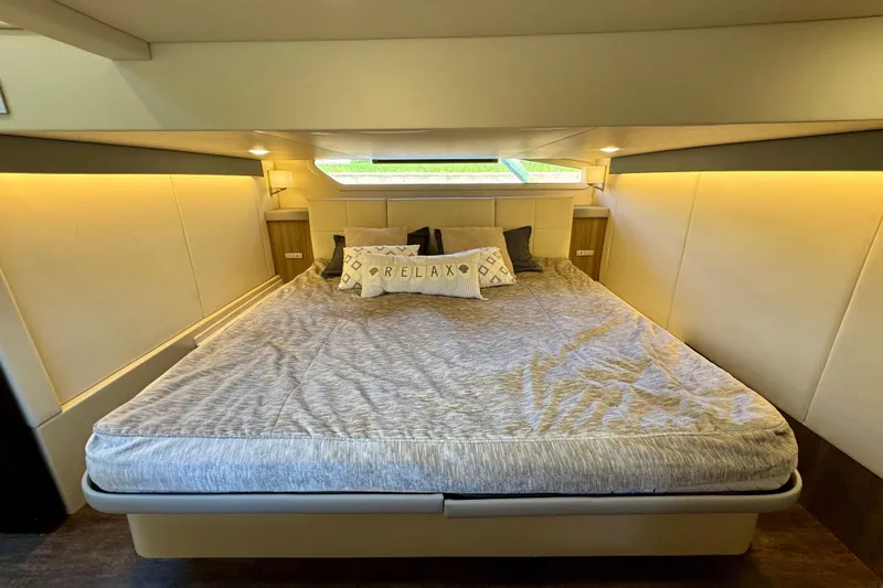Carchi Yacht Photos Pics Luxurious bedroom interior of 2022 Regal 42 XO yacht with cozy bedding and ambient lighting.