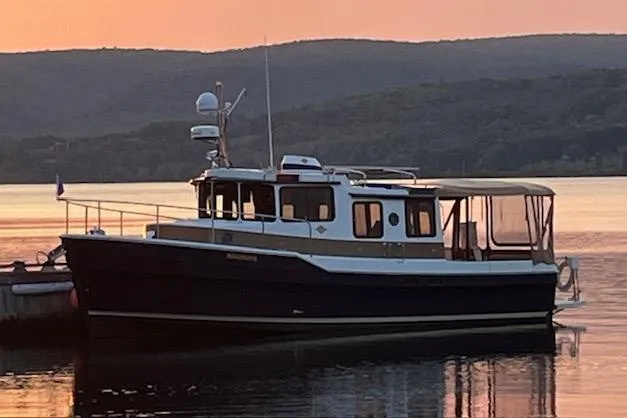Mystic Yacht Photos Pics 2014 Ranger Tugs R-31 boat on calm water at sunset with hills in background.