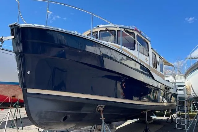 Mystic Yacht Photos Pics 2014 Ranger Tugs R-31 boat on stands, blue hull, clear sky background.
